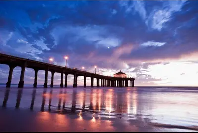 a pier on the water with the sun setting at Bay Breeze Hideaway in Lawndale