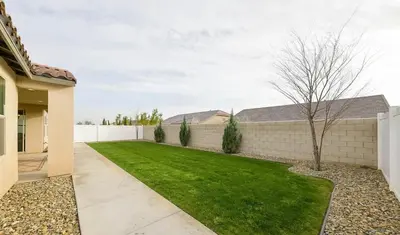 a backyard with a fence and a green lawn at Modern 3BR Home Gated Community in Bakersfield