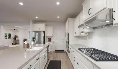 a kitchen with white cabinets and a stove top oven at Modern 3BR Home Gated Community in Bakersfield