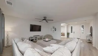 a living room with a white couch and a ceiling fan at Modern 3BR Home Gated Community in Bakersfield