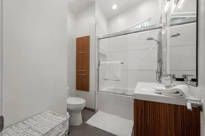 a white bathroom with a toilet and a sink at Hillside Modern Retreat with pool BBQ and MORE in Los Angeles