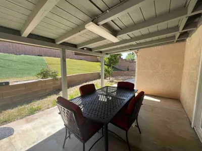 a patio with a table and chairs on a porch at Beautiful and cozy! in Palmdale