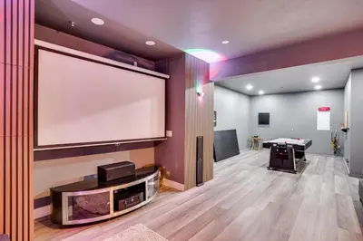 a large projection screen on a wall in a room at 3 Mi to Disneyland Home with Hot Tub and Game Room in Anaheim