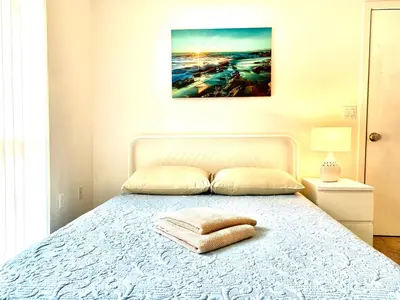 a bedroom with a bed with a blanket and a picture at Western Marathon in Los Angeles