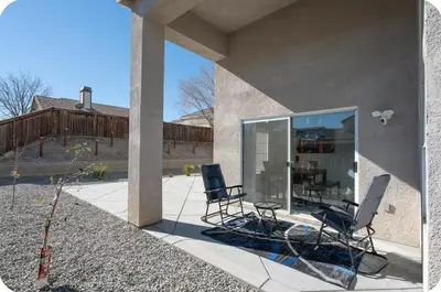 two chairs and a table in front of a house at Desert View in Victorville