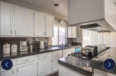 a kitchen with white cabinets and a stove top oven at Desert View in Victorville