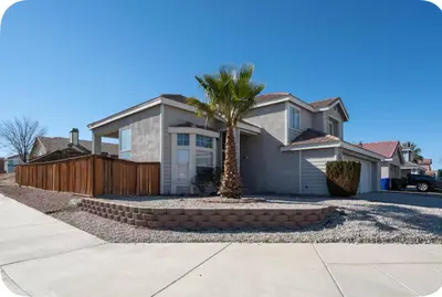 a house with a palm tree in front of it at Desert View in Victorville