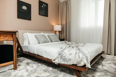 a bedroom with a bed with white sheets and pillows at Cozy 2BD apartment in Los Angeles