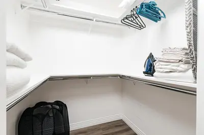 a closet with white walls and a shelf with towels at Cozy 2BD apartment in Los Angeles