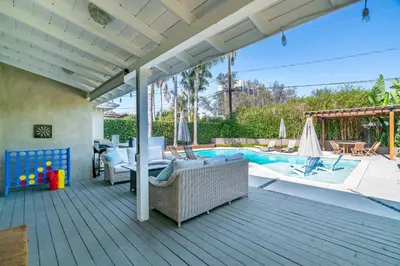 an outdoor deck with a pool and a patio furniture at Modern Pool house with hot tub and relaxing backyard in Long Beach