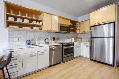 a kitchen with white cabinets and stainless steel appliances at Beautiful Apartment in Hollywood in Los Angeles