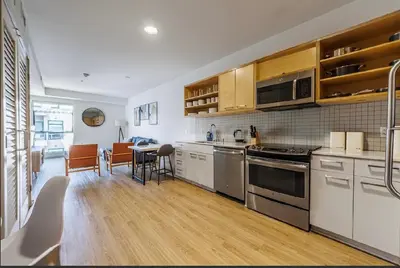a kitchen with stainless steel appliances and a dining room at Beautiful Apartment in Hollywood in Los Angeles
