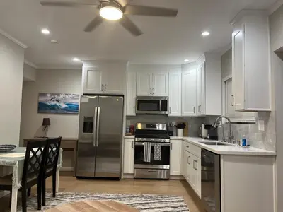 a kitchen with white cabinets and a stainless steel refrigerator at Guest House in Torrance