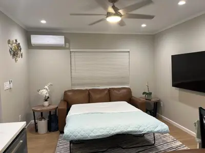 a living room with a couch and a flat screen tv at Guest House in Torrance