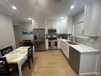a kitchen with white cabinets and stainless steel appliances at Guest House in Torrance