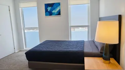 a bedroom with a bed with a lamp and windows at Modern Boutique Living in Culver City in Los Angeles