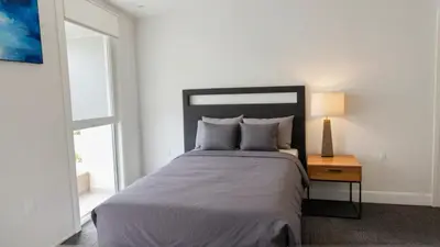 a bedroom with a large bed and a table with a lamp at Modern Boutique Living in Culver City in Los Angeles