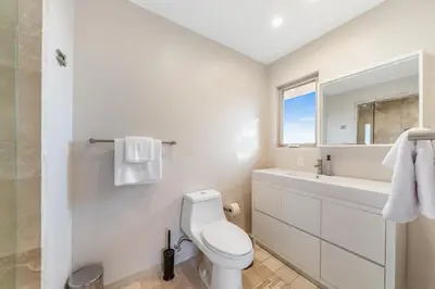 a white bathroom with a toilet and a sink at Spacious Hollywood Private Villa with 7 Bedrooms and Pool in Los Angeles