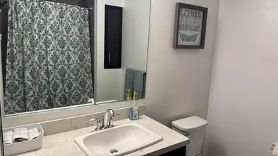 a bathroom with a sink and a toilet and a mirror at Vine & Sunset Loft Free Parking and WIFI in Los Angeles