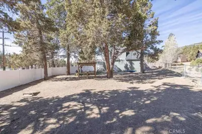 a large yard with trees and a fence at Navigate Stays Best Location Pet Friendly Games in Big Bear City