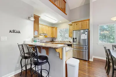 a kitchen with wooden cabinets and stainless steel appliances at 7 Mi to Snow Valley Mountain Resort Quiet Cabin in Running Springs