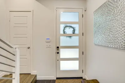a hallway with a white door and a picture at 2 Mi to Cabrillo Beach Luxe LA Gem with Balcony in San Pedro