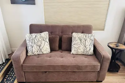 a brown couch with two pillows on it in a living room at Coldwater Canyon ADU in Los Angeles