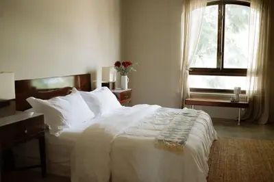 a bedroom with a large white bed and a window at Stylish Penthouse in West Hollywood in Los Angeles