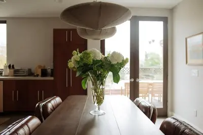 a vase of flowers on a table in a kitchen at Dreamy Mid-Century Modern Pad in Los Angeles