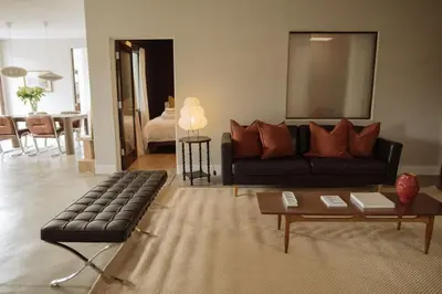a living room with a black couch and a table at Dreamy Mid-Century Modern Pad in Los Angeles