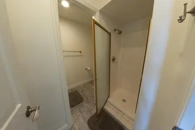 a bathroom with a shower with a mirror at Ocean Blue in Oxnard