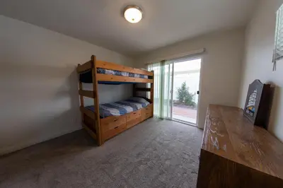 a bedroom with a bunk bed and a sliding glass door at Ocean Blue in Oxnard