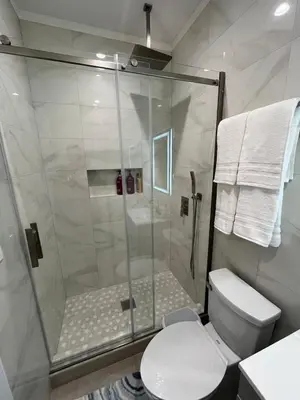 a bathroom with a glass shower with a toilet at House in Torrance