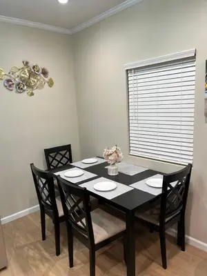 a black dining room table with chairs and a window at House in Torrance