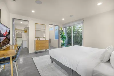 a white bedroom with a bed and a desk at Solara Point in Los Angeles