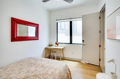 a bedroom with a bed and a table and window at Shop, Dine and Walk to Ocean Redondo Beach Apt! in Redondo Beach