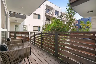 a balcony with chairs and a wooden fence at The Amber Serene Peaceful Retreat Pool Gym And Jacuzzi in Los Angeles