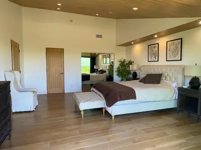 a large bedroom with a bed and a chair at Spectacular City Mountain Views Remodeled Open Plan 3 bdr Home Pool Jacuzzi Oasis in Engine Company Number 109 Heliport