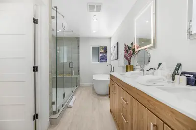 a white bathroom with two sinks and a shower at Rancho Haven in Los Angeles