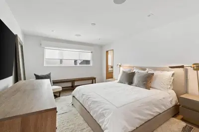 a bedroom with a large white bed and a chair at Playa Del Sol by Stay Awhile Villas in Malibu Beach