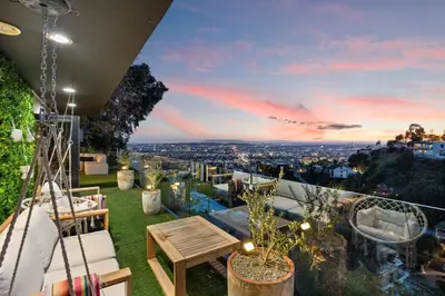 a rooftop garden with a view of the city at dusk at Six Senses by Stay Awhile Villas in Los Angeles
