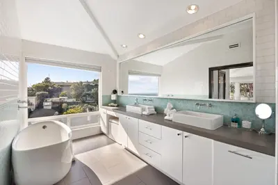 a bathroom with two sinks and a large mirror at Six Senses by Stay Awhile Villas in Los Angeles