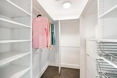 a walk in closet with white walls and white shelves at Six Senses by Stay Awhile Villas in Los Angeles