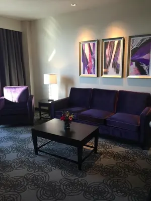 a living room with a blue couch and a coffee table at Parkwest Bicycle Casino in Bell Gardens