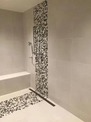 a bathroom with a shower with a mosaic tile wall at Parkwest Bicycle Casino in Bell Gardens