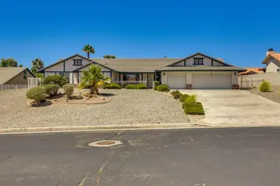 a large house with a driveway in front of it at Pool, Spa and Mountain Views Apple Valley Retreat! in Apple Valley
