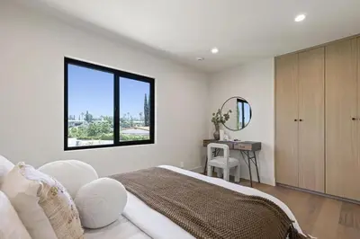 a bedroom with a bed and a mirror and a table at The Dona Modern in Los Angeles