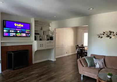a living room with a couch and a tv on a wall at Northridge 3BR 2BA Home with Pool on a Tree-Lined street, Close to CSUN in Northridge