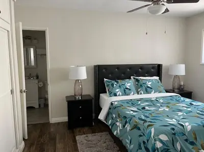 a bedroom with a bed with a blue comforter and two lamps at Northridge 3BR 2BA Home with Pool on a Tree-Lined street, Close to CSUN in Northridge