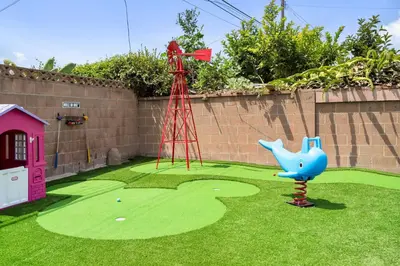 a playground with a miniature golf course with a sprinkler at Enchanted Dreams by OC Adventure Homes in Garden Grove